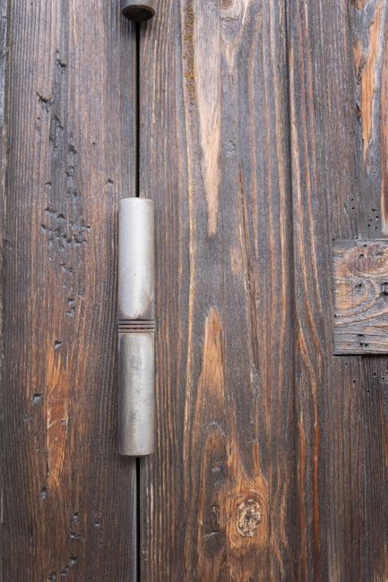 Close-up of weathered wood boards with a steel handle