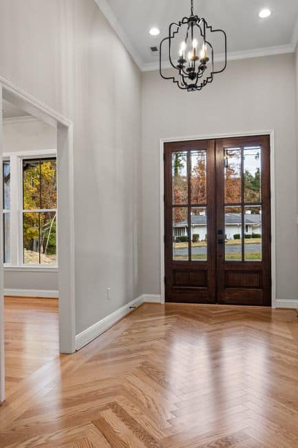 Dark wood French doors in a bright hallway