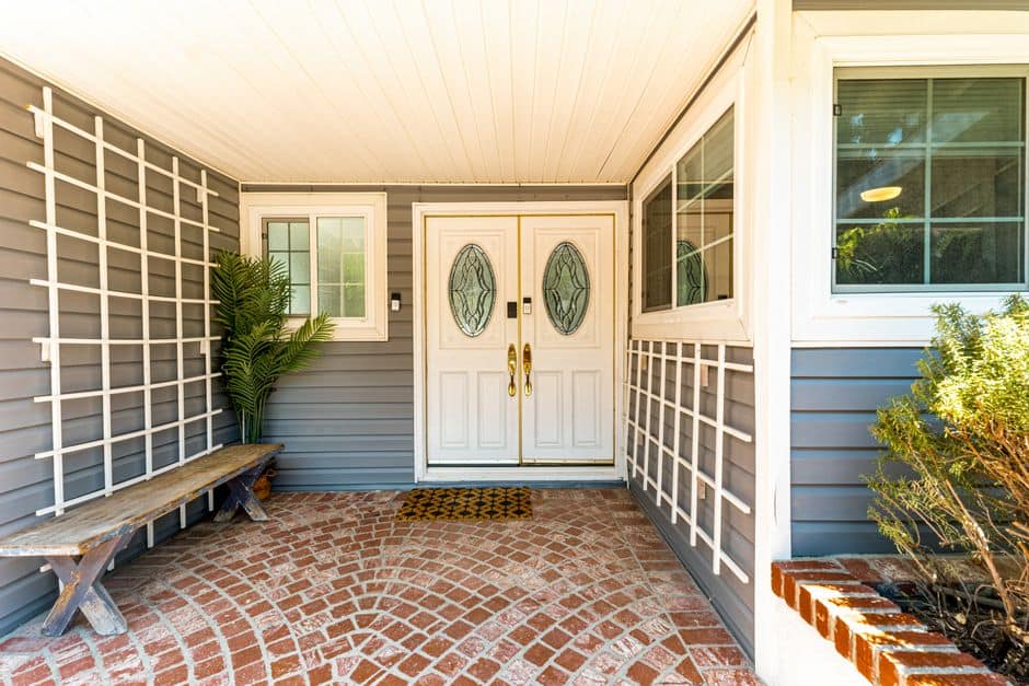White double entry doors with oval glass under a covered porch