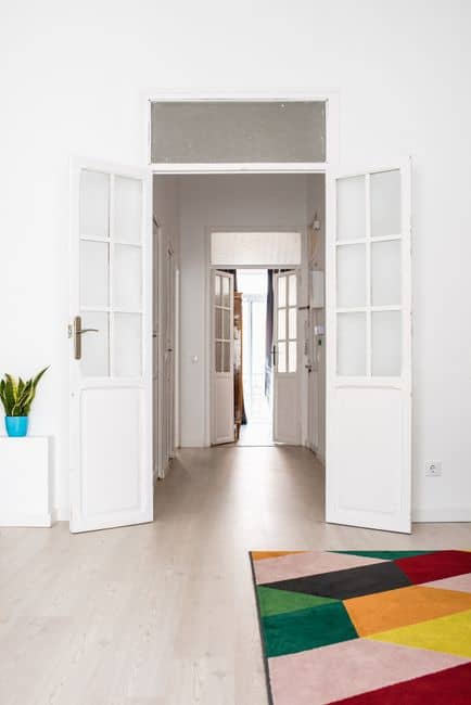 A wide open white wooden door in a bright hallway