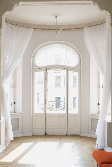 White French doors with sheer white curtains in a bright entrance