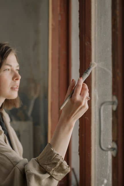 Woman painting a door frame with a brush