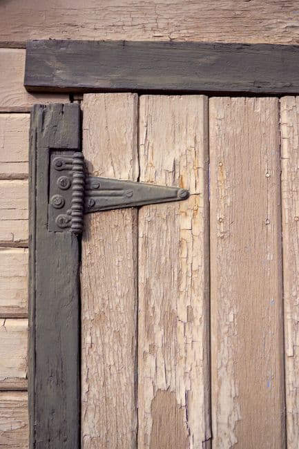 A metal handle on an old wooden door