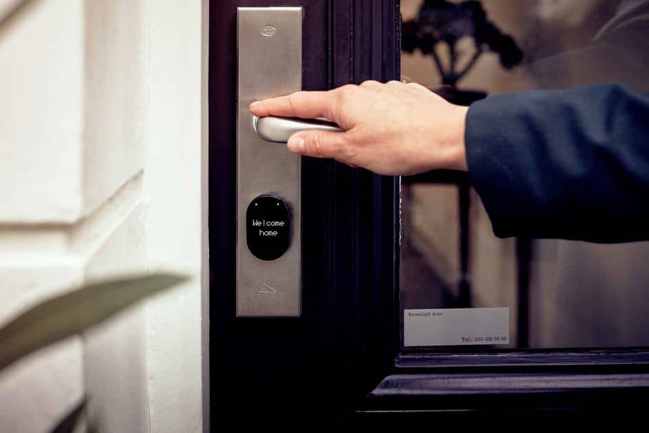 Hand on a smart lock at a dark door