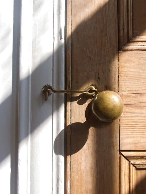 A brass door knob on a wooden door