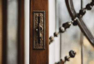 -up of two metal flush bolts installed on the interior of a French door, showing the intricate details of the hardware