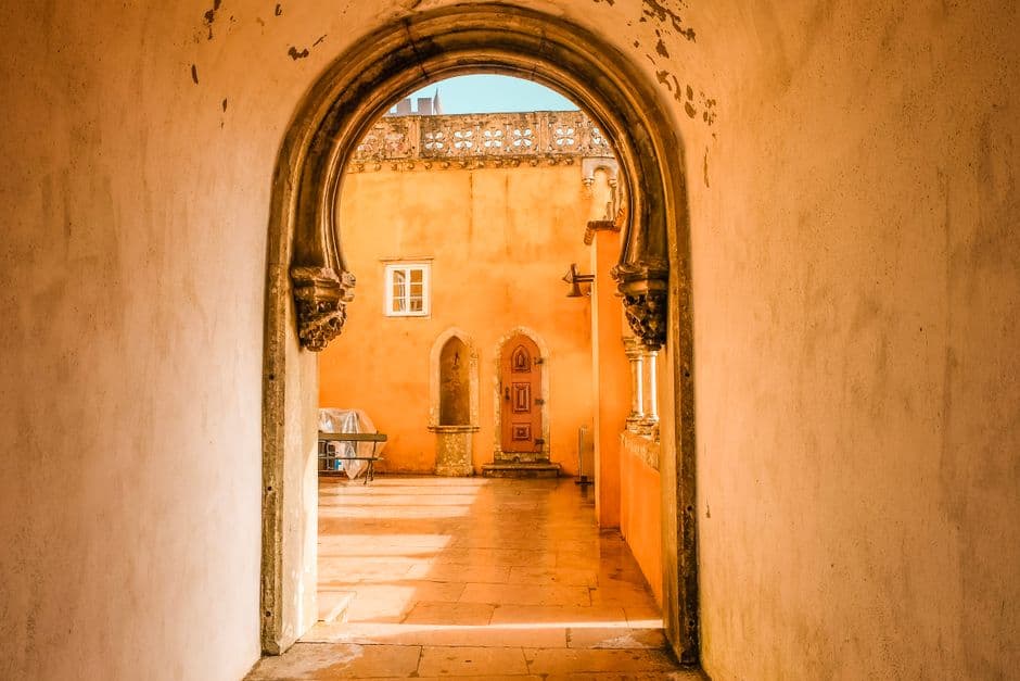 Arched doorway opening onto a sunlit courtyard