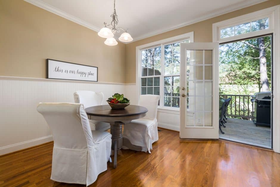 French door standing open from a dining room onto a deck